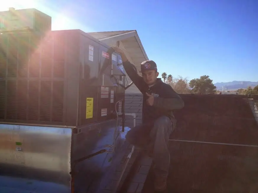 HVAC technician performing Air Duct Cleaning on a rooftop unit in Golden Valley